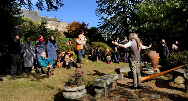 Storyteller speaking to crowd at outdoor v venue at the Storytelling Festival