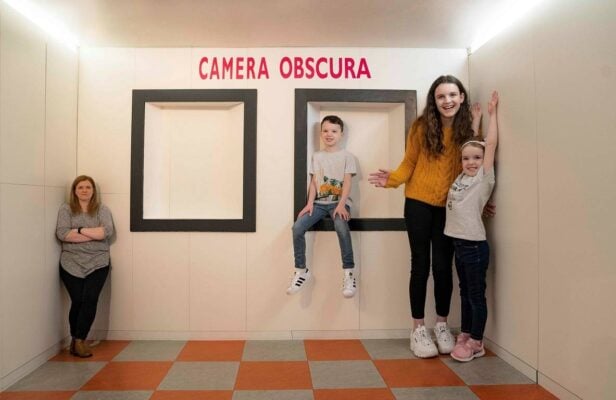 A mum and children in a room showing forced perspective., Camera Obscura & World of Illusions, Edinburgh