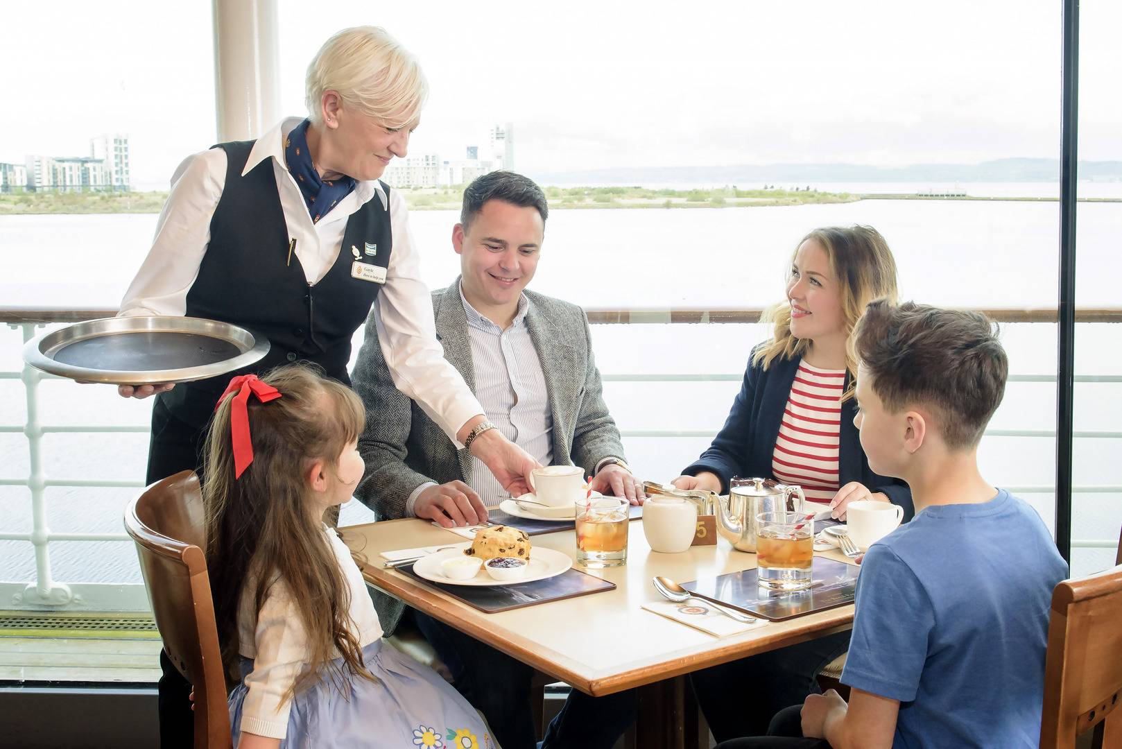 Family sit in the Royal Deck Tea Room having scones and tea., Helen Pugh