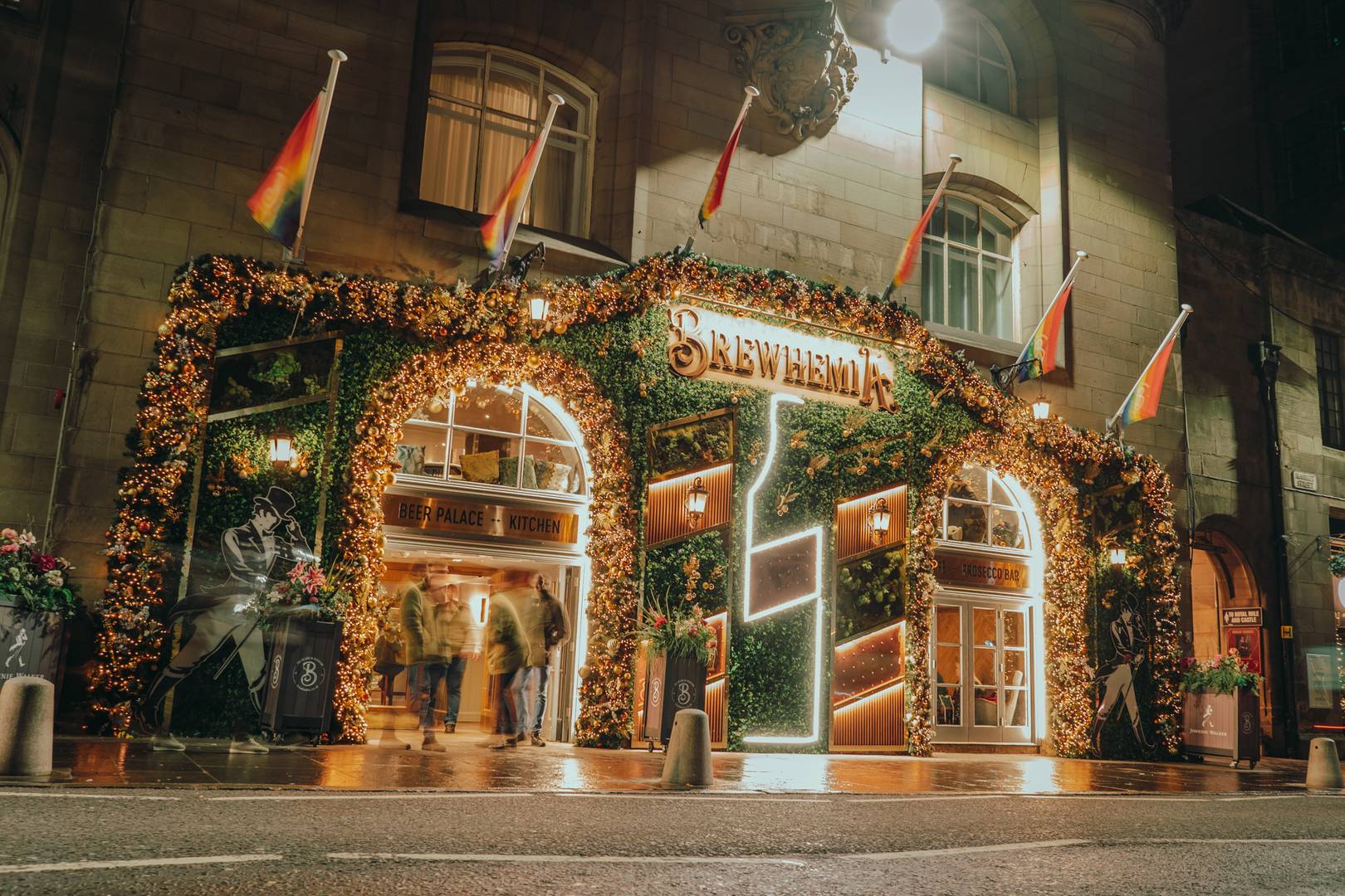 The outside of Brewhemia Edinburgh at night. Includes lighten up Brewhemia sign, LGBTQ flags and floral façade.,© Brewhemia Edinburgh