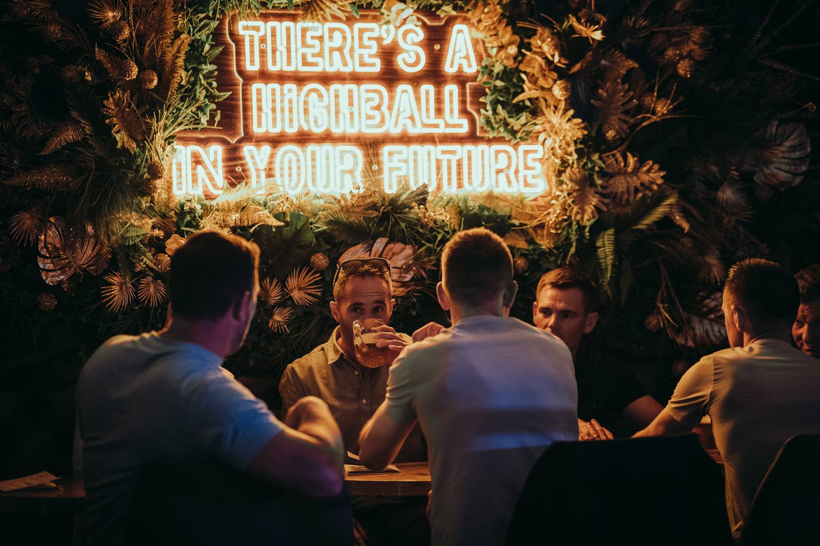 There is a highball in your future sign with group enjoying drinks