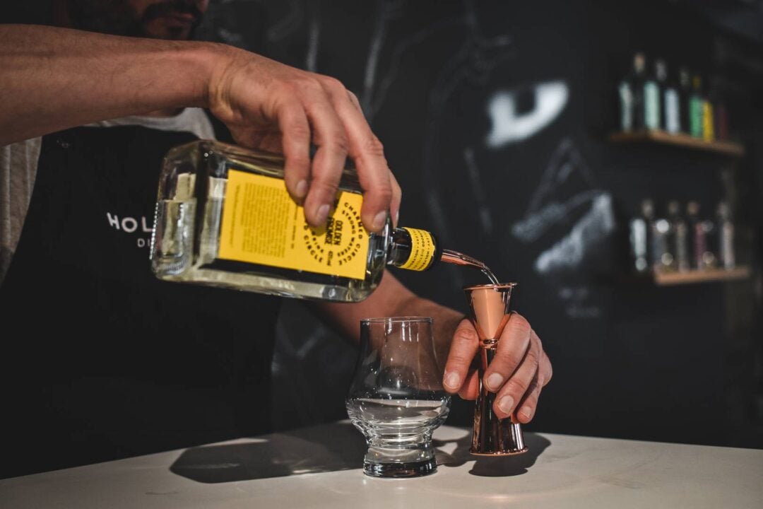 Man pouring gin into a measurer