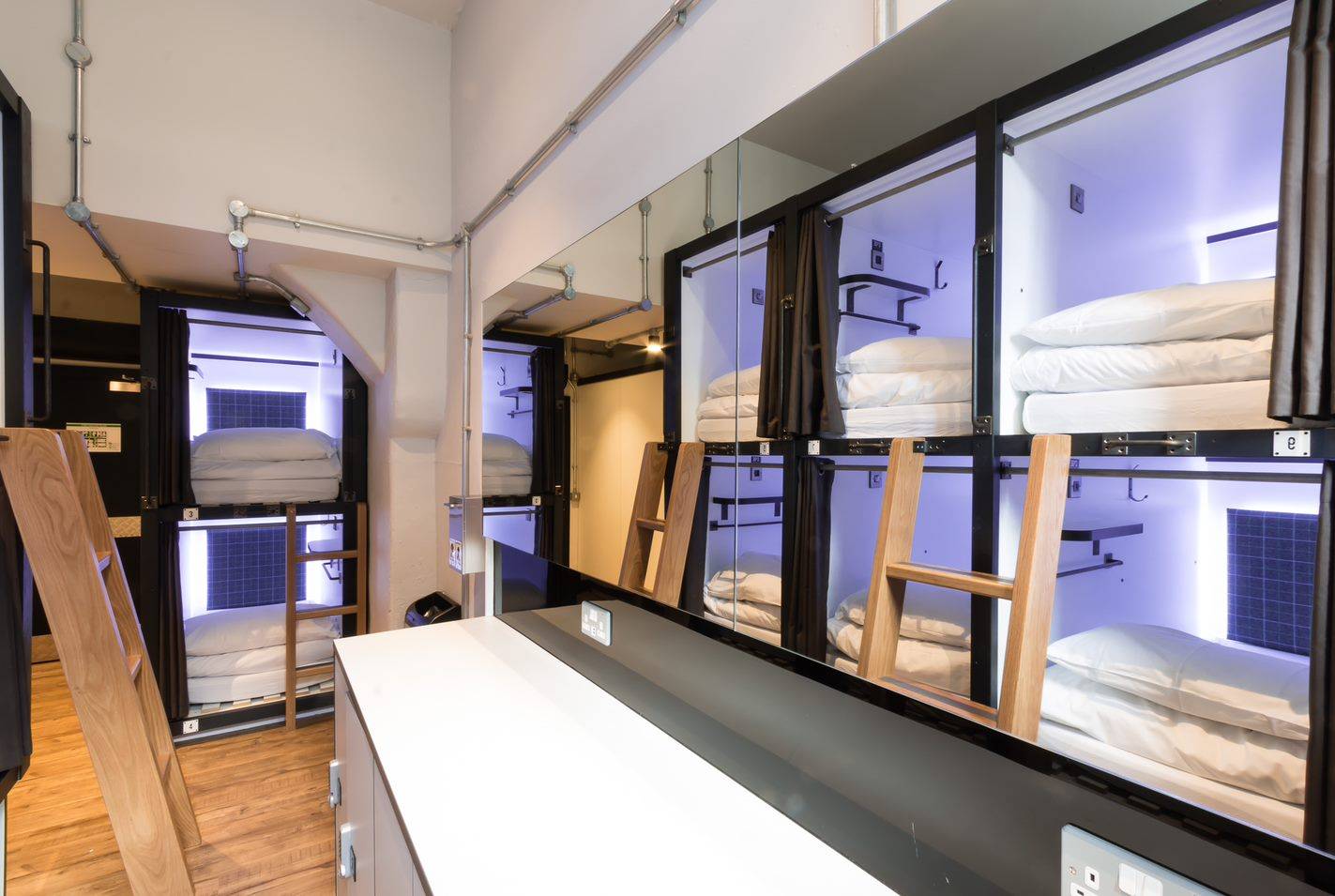 view of 8 sleeping pods in 8 bed dormitory. All with linen and ambient light., Code Hostels