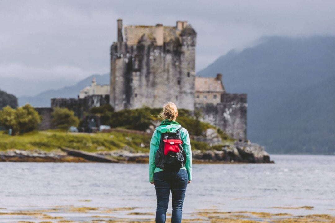 Young female backpacker at Eilean Donan Castle