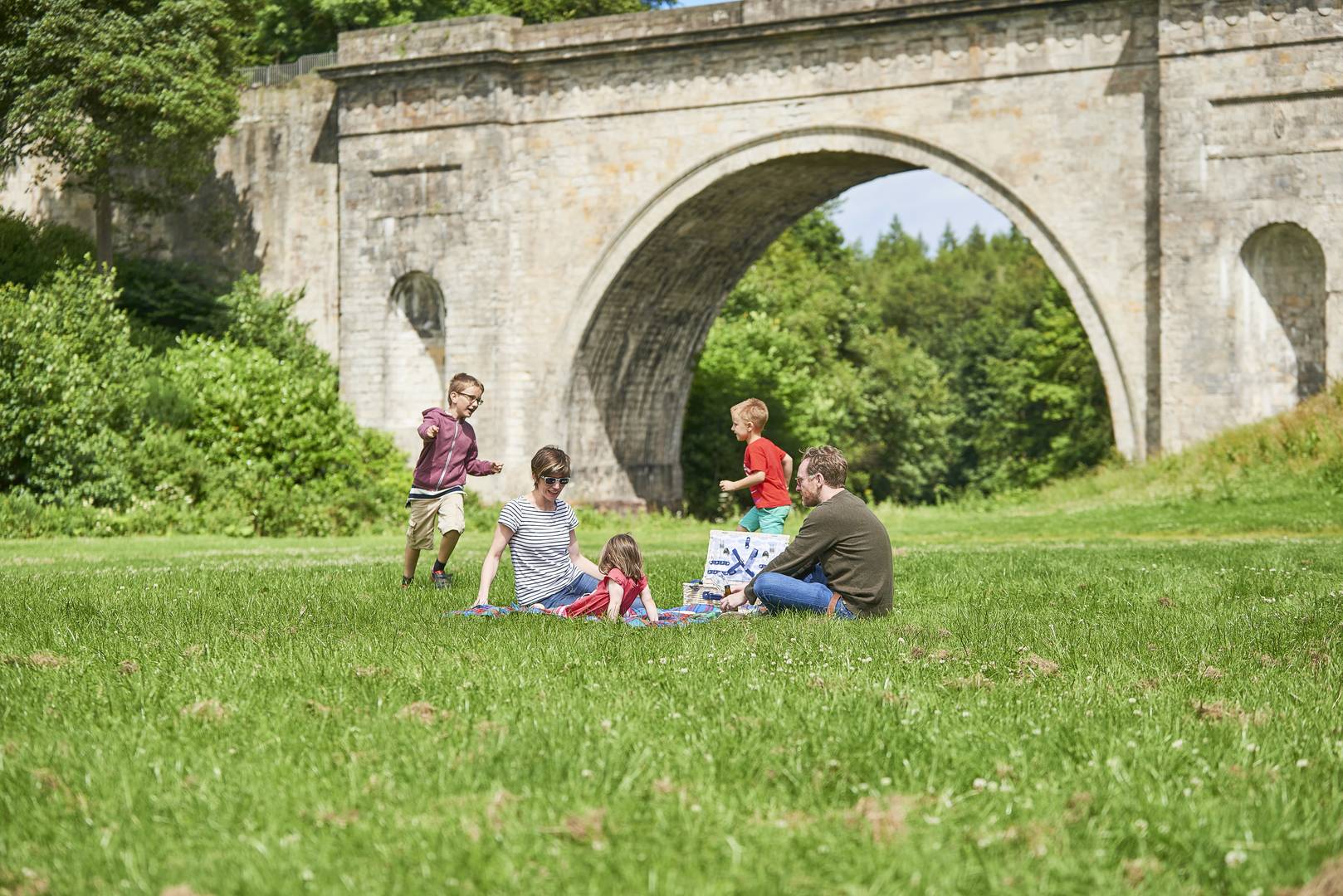 Family enjoying a picnic in front of Montagu Bridge at Dalkeith Country Park, Dalkeith Country Park