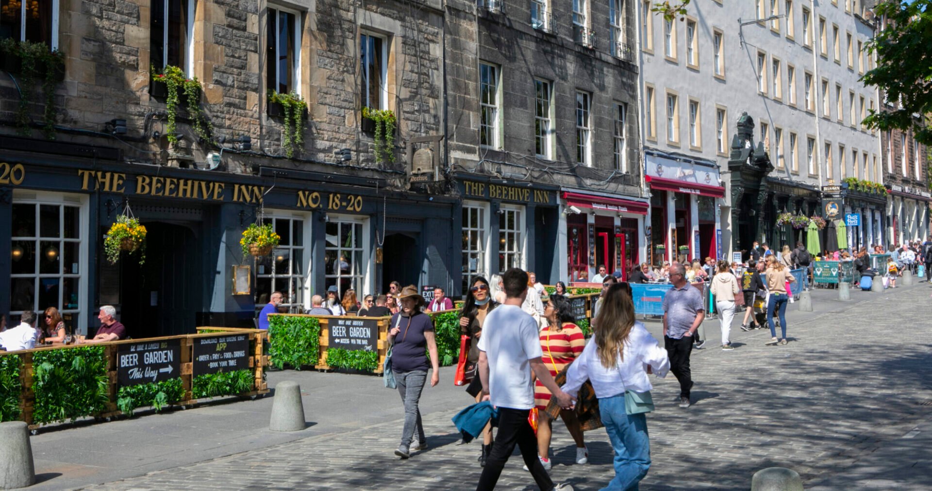 People walking in Grassmarket past the Beehive Inn