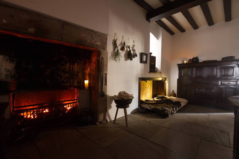 John Riddoch and Margaret Noble’s kitchen from 1632, showing a large hearth and fold-down servant’s bed, National Trust for Scotland