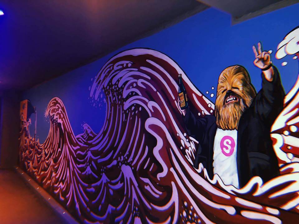 Wall mural. Lewis Capaldi wearing a Chewbacca mask holding a bottle of Buckfast with Hokusai Buckfast waves in the background., Subway Cowgate