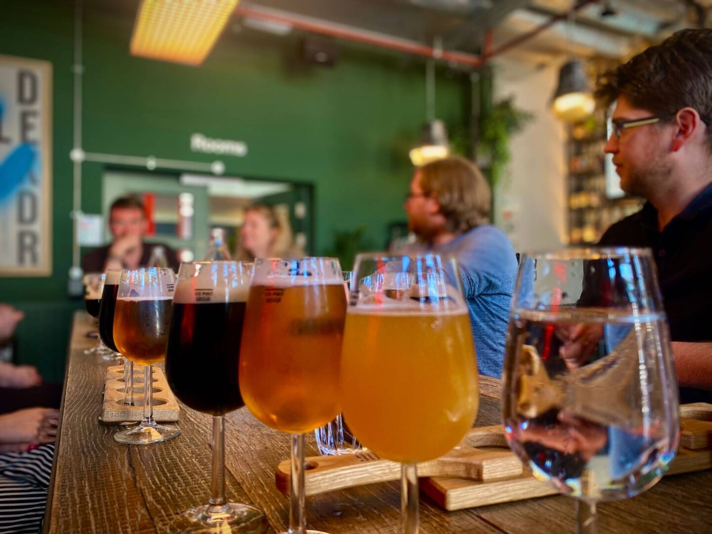 The Edinburgh Beer Tour being hosted by tour guide Gary, with a row of beers in the foreground and guests listening to Gary in the background,© EDI Tours