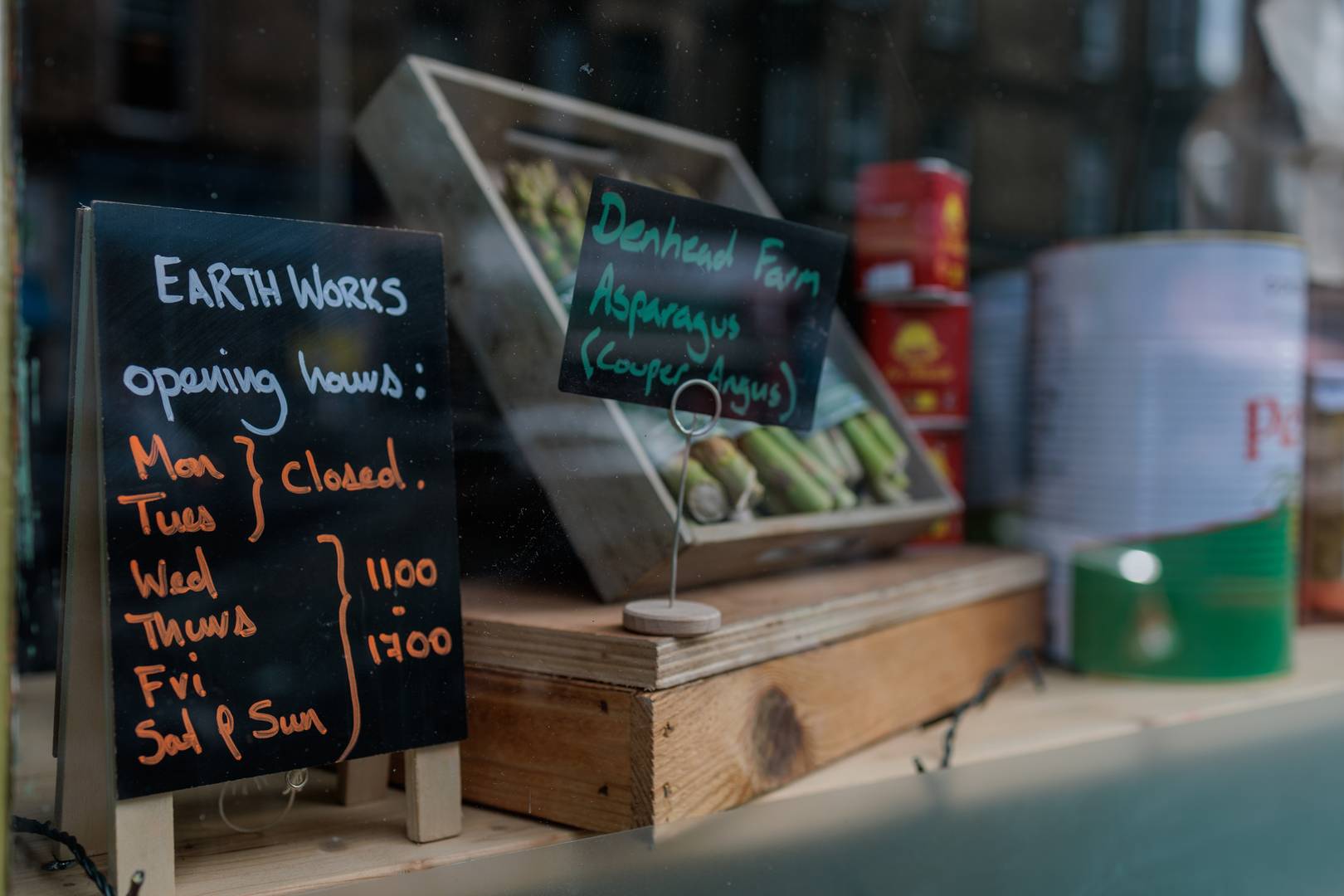 Earth Works opening hours and box of asparagus in shop window