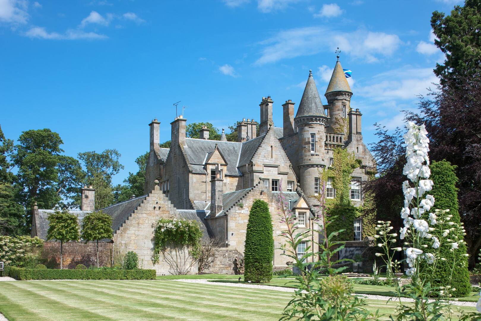 Image of the castle on a sunny day from the gardens,© Carlowrie Castle