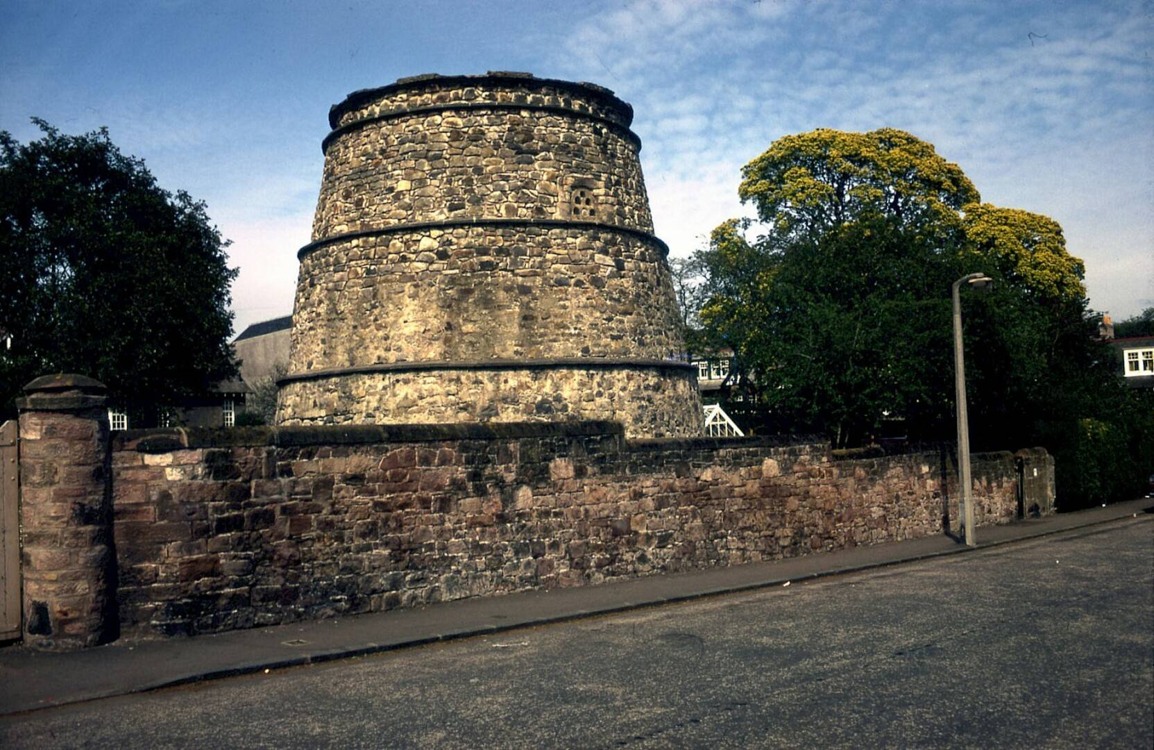 Image of the stone three tiered dovecot behind a stone wall,© Image Credit: Corstorphine Trust