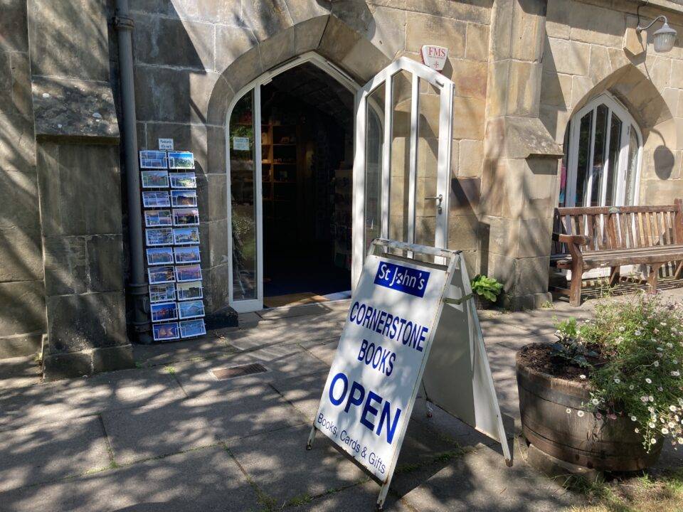 Front door of bookshop and a display of postcards