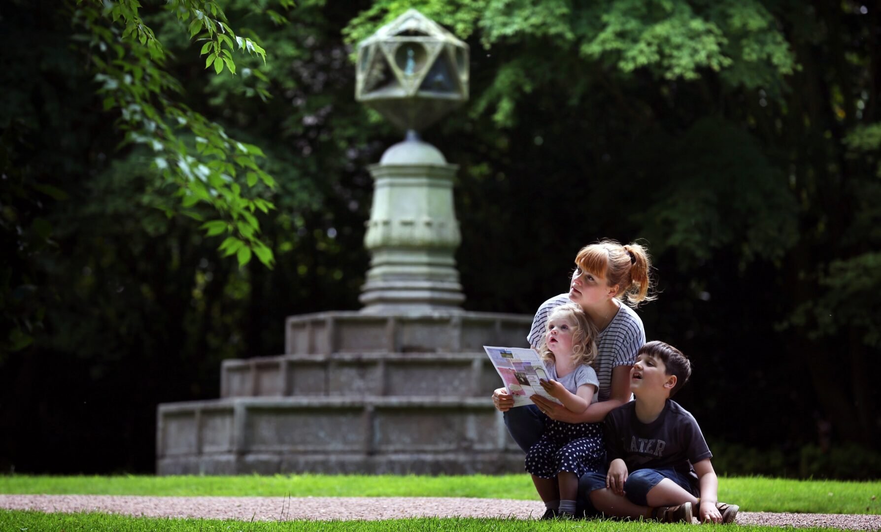 Mother and 2 children taking part in a an activity trail in the gorunds of the Palace of Holyrood House