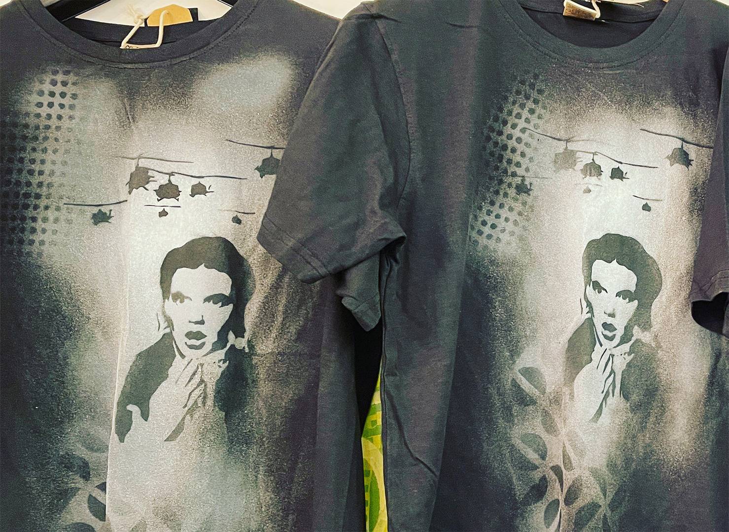 two black t-shirts with white spray painting of girls face and helicopters, Gerry Gapinski