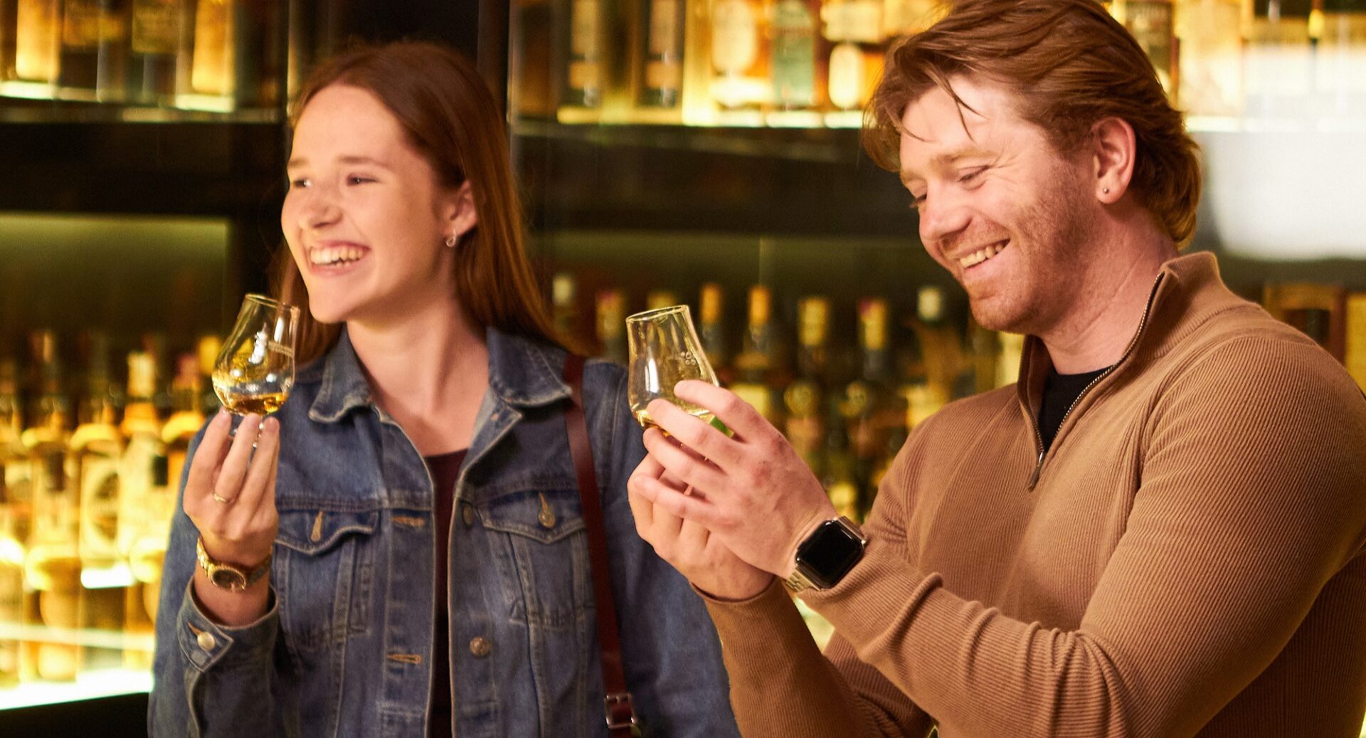 Scotch Whisky Experience, lady and man smelling whisky aromas surrounded by whisky collection