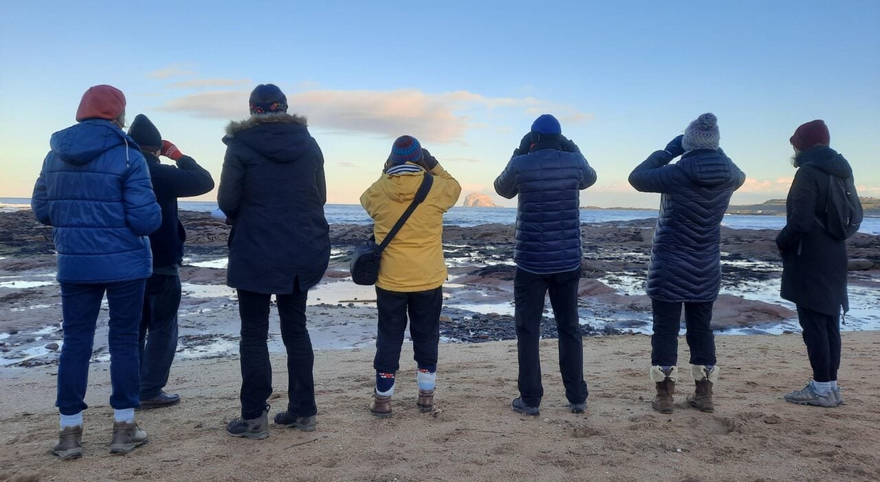People looking out to sea towards Bass Rock