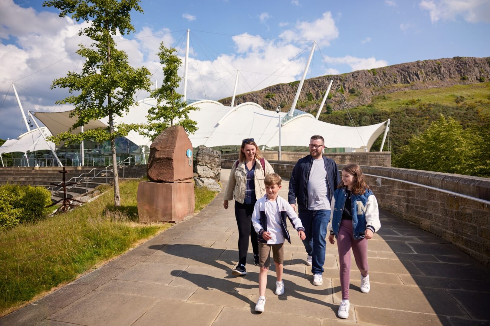 Family coming out of Dynamic Earth on sunny day.