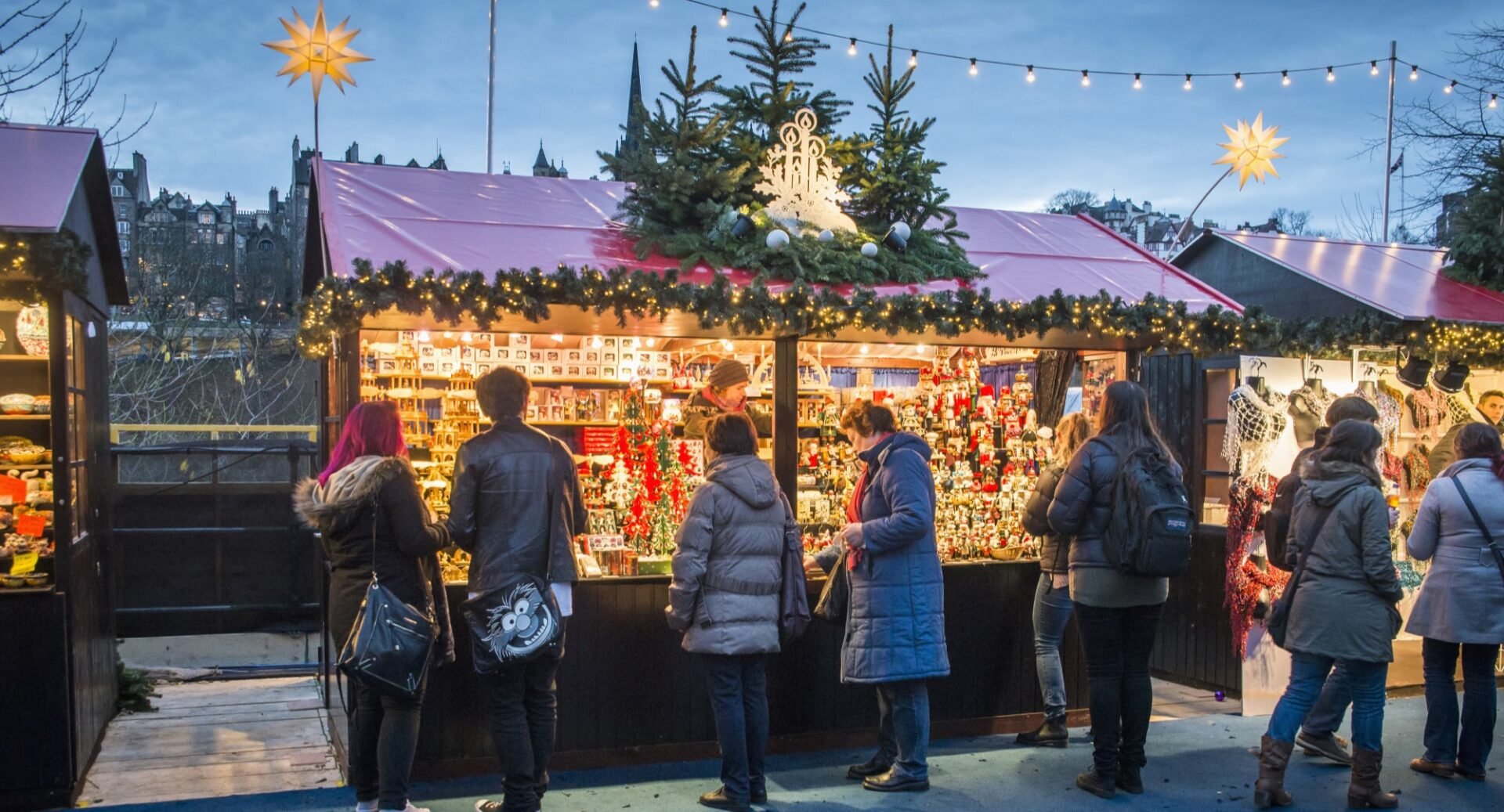 Edinburgh Christmas Market with people browsing at festive market stall.