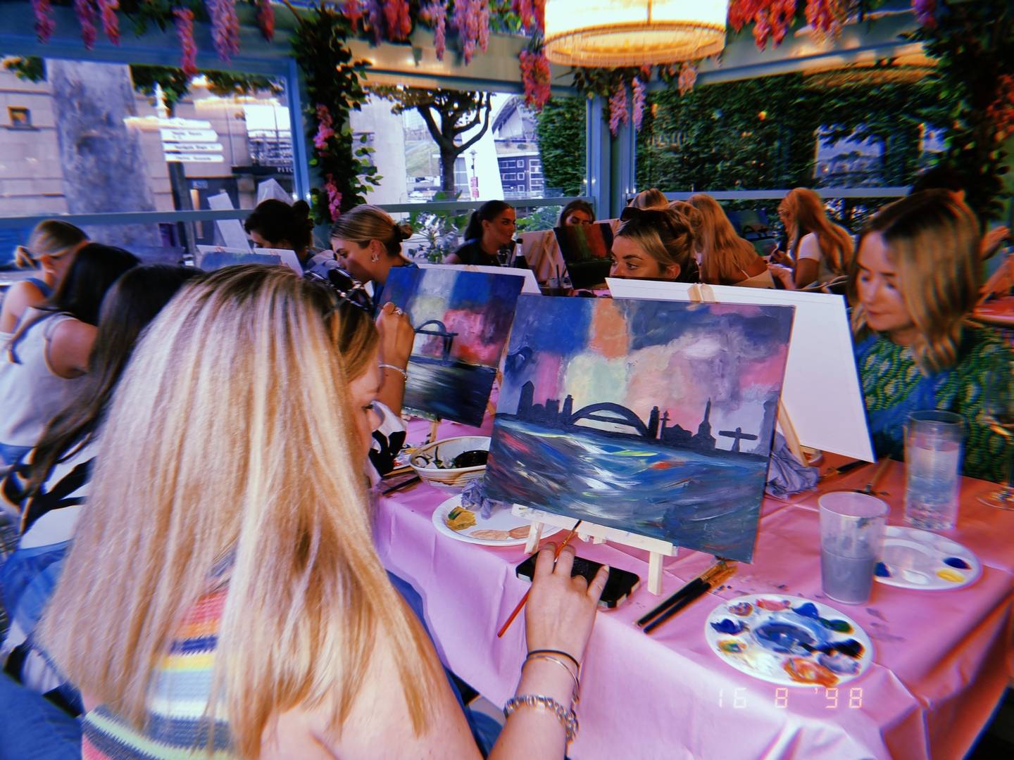 Group of girls painting at Boozy Brushes