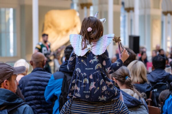 Young girl dressed as a unicorn on her dad's shoulders