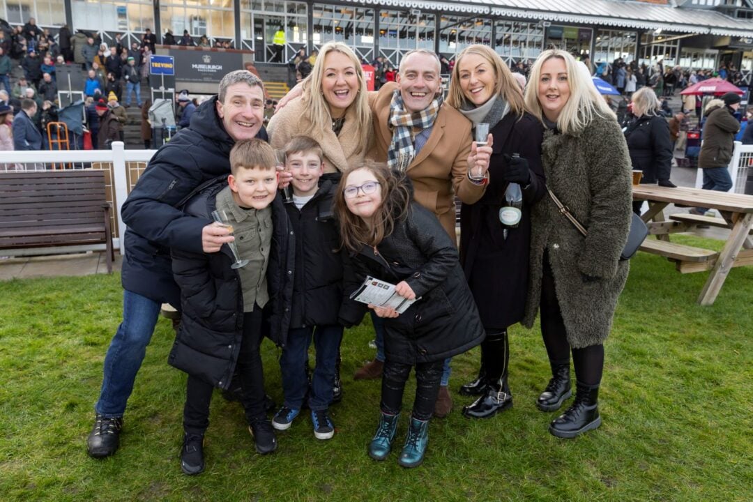 family happily posing for a picture at musselburgh racecourse