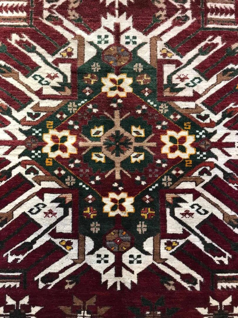 Close up of red, green and white patterned rug