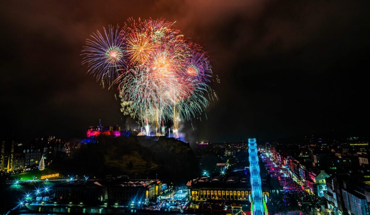 Hogmanay street party multi-coloured fireworks above edinburgh rainbow christmas lights