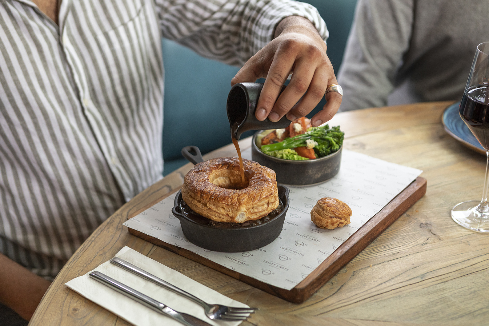 Gravy being poured into giant Yorkshire pudding