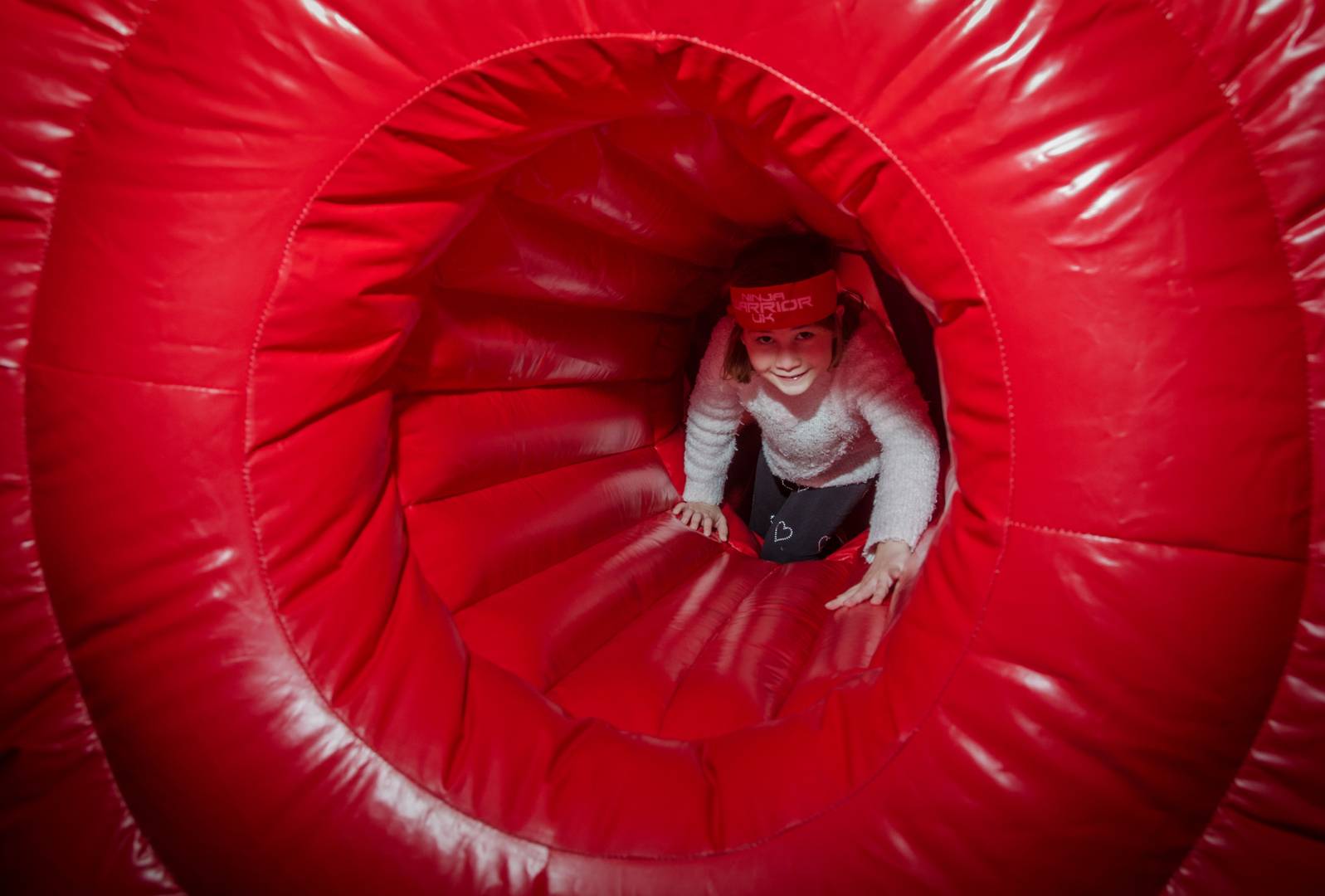 Young girl crawling through tunnel