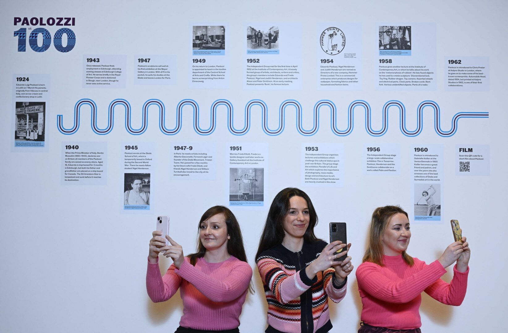 3 ladies taking selfies next to Timeline Board of 100 years of Eduardo Paolozzi at National Galleries Scotland: Modern Two.