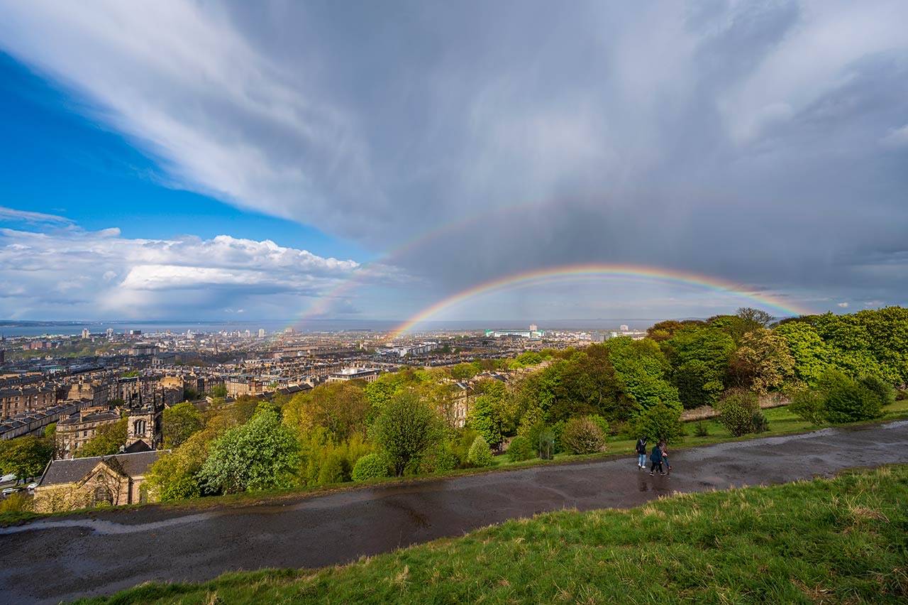 Path above Edinburgh buildings with rainbow in background