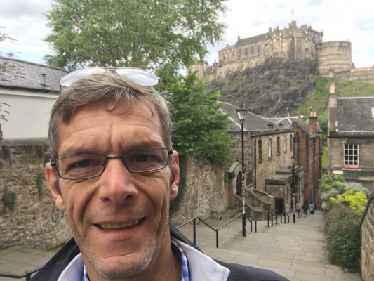 Selfie image of Paul Stewart at the Vennel Steps with Edinburgh Castle in background