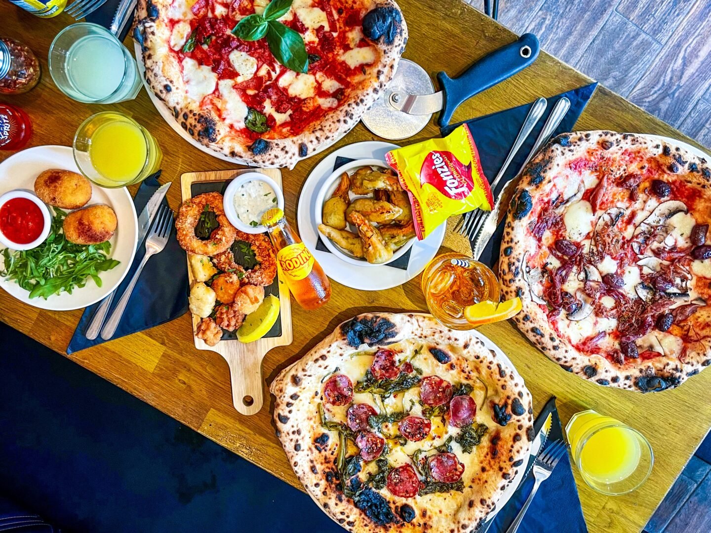 A spread of pizza, juice and sides offered by Matto Pizza