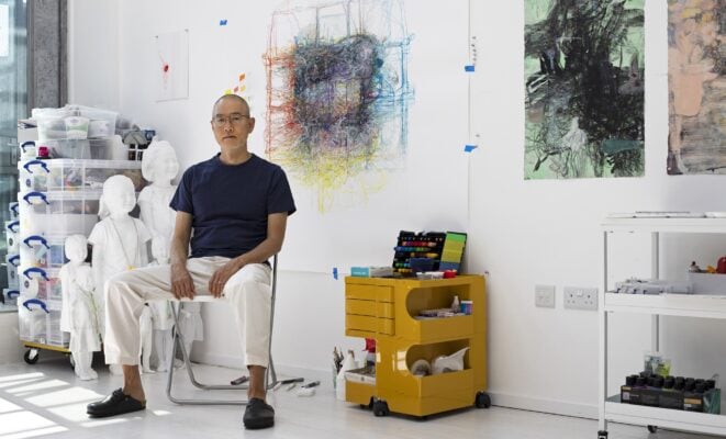 Do Ho Suh sitting next to his Tracing Time exhibition.