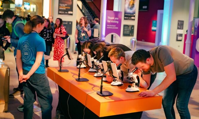 People looking through microscopes at the Edinburgh Science Festival