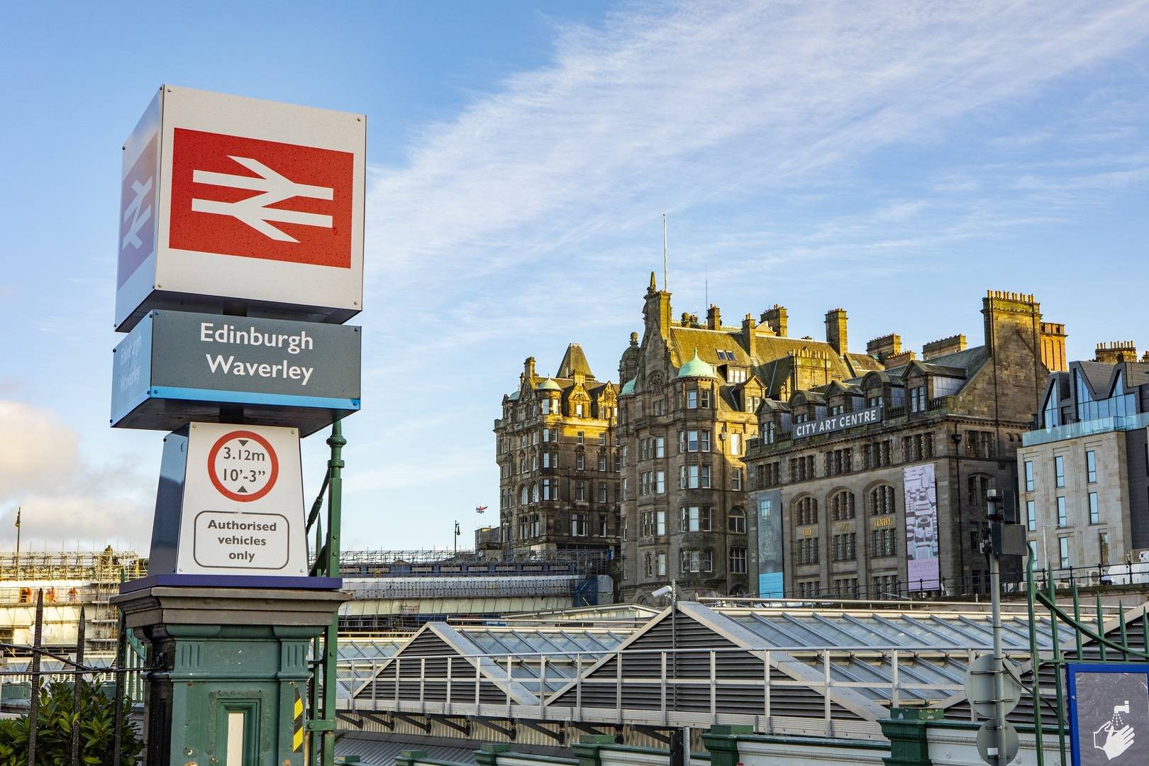 Image of Edinburgh Waverley sign with Balmoral Hotel in the background and blue sky