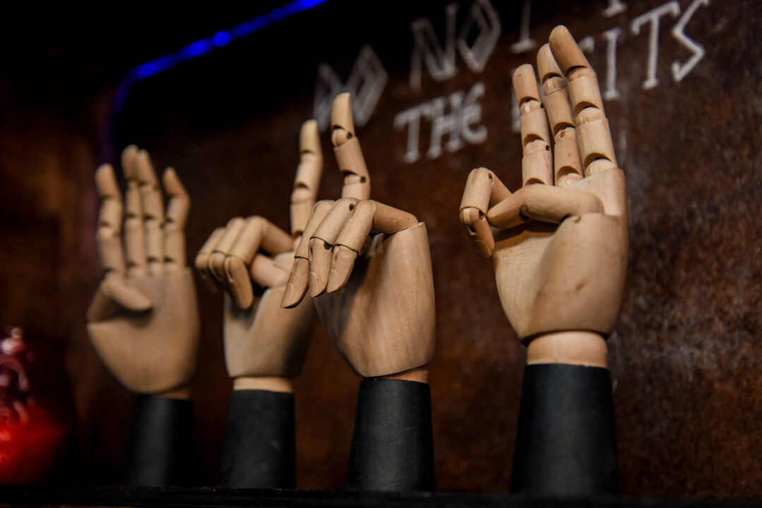 4 wooden hands, each holding up different fingers.