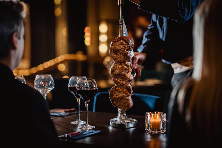 Rodizio style meat being carved at a table