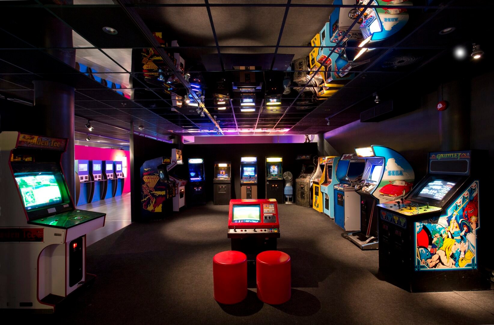 Arcade machines and computers with games set up for museum exhibition.