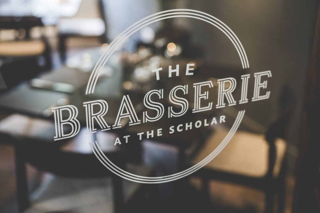 The Brasserie logo on a glass door.