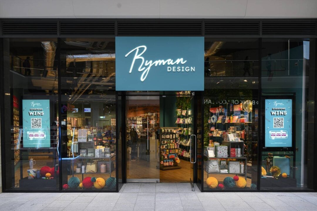 The storefront of Ryman Design Edinburgh. There are two TV screens on either side of the entrance and a large blue 