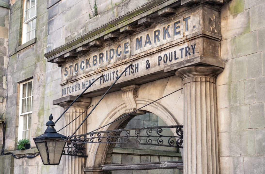 An old sign over an archway in the Stockbridge district of Edinburgh, for an old meat, fruits, fish and poultry market. A modern weekend community market continues at a nearby site.