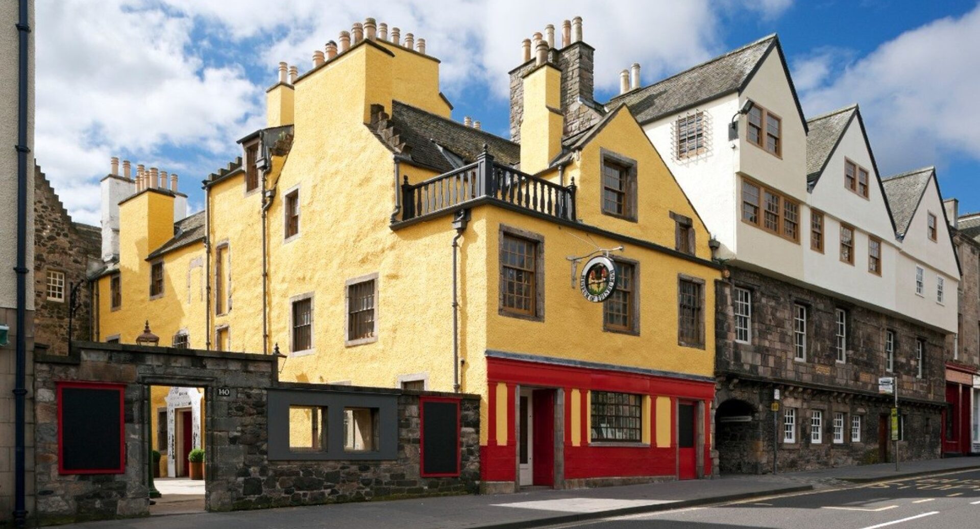 A shot from the Canongate of the exterior of the Museum of Edinburgh, which is bright red and yellow