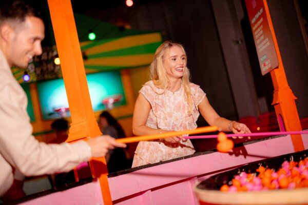 Lady playing Hook the Duck at Fayre Play