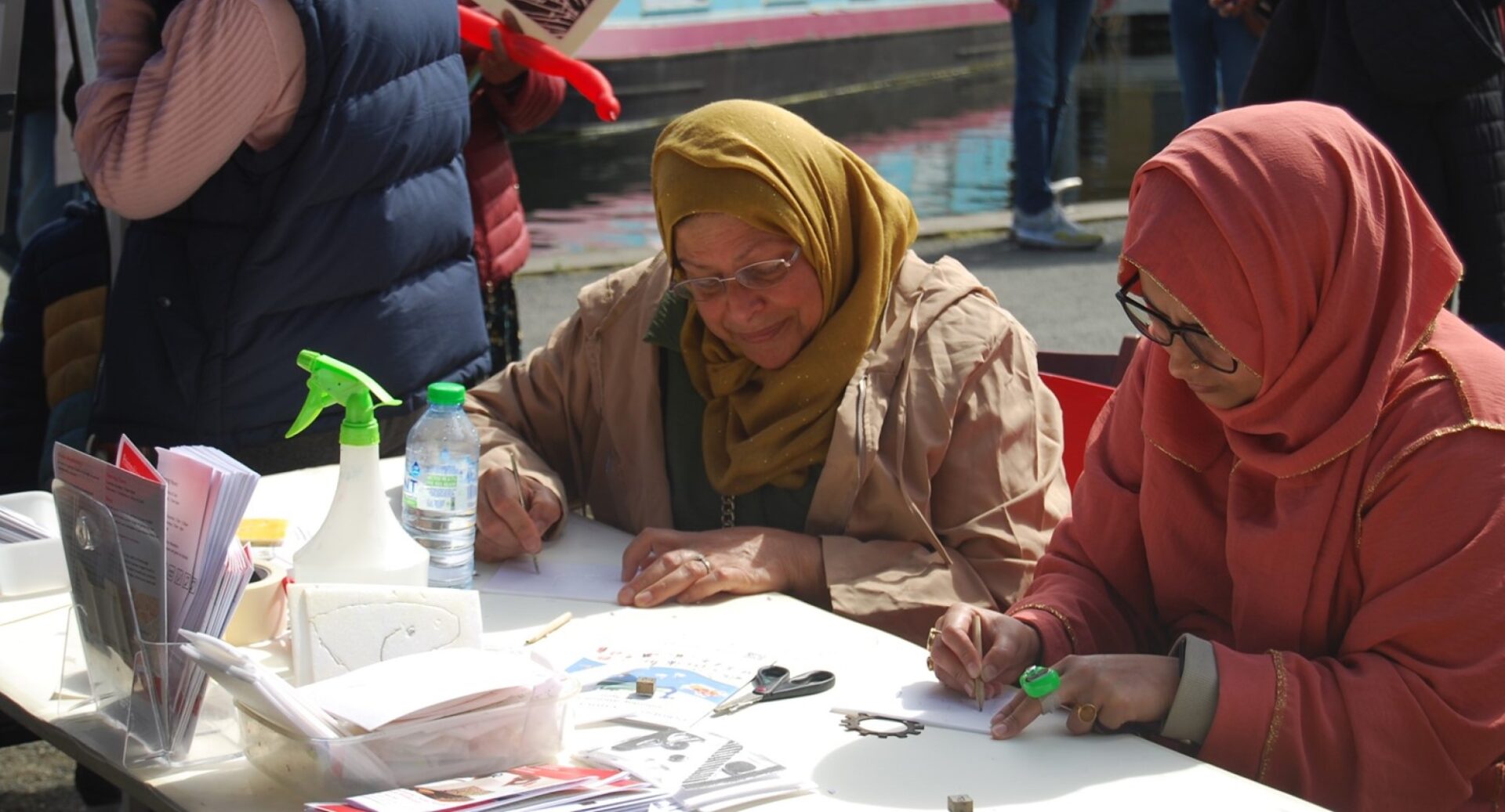 Two women sitting at a table sketching