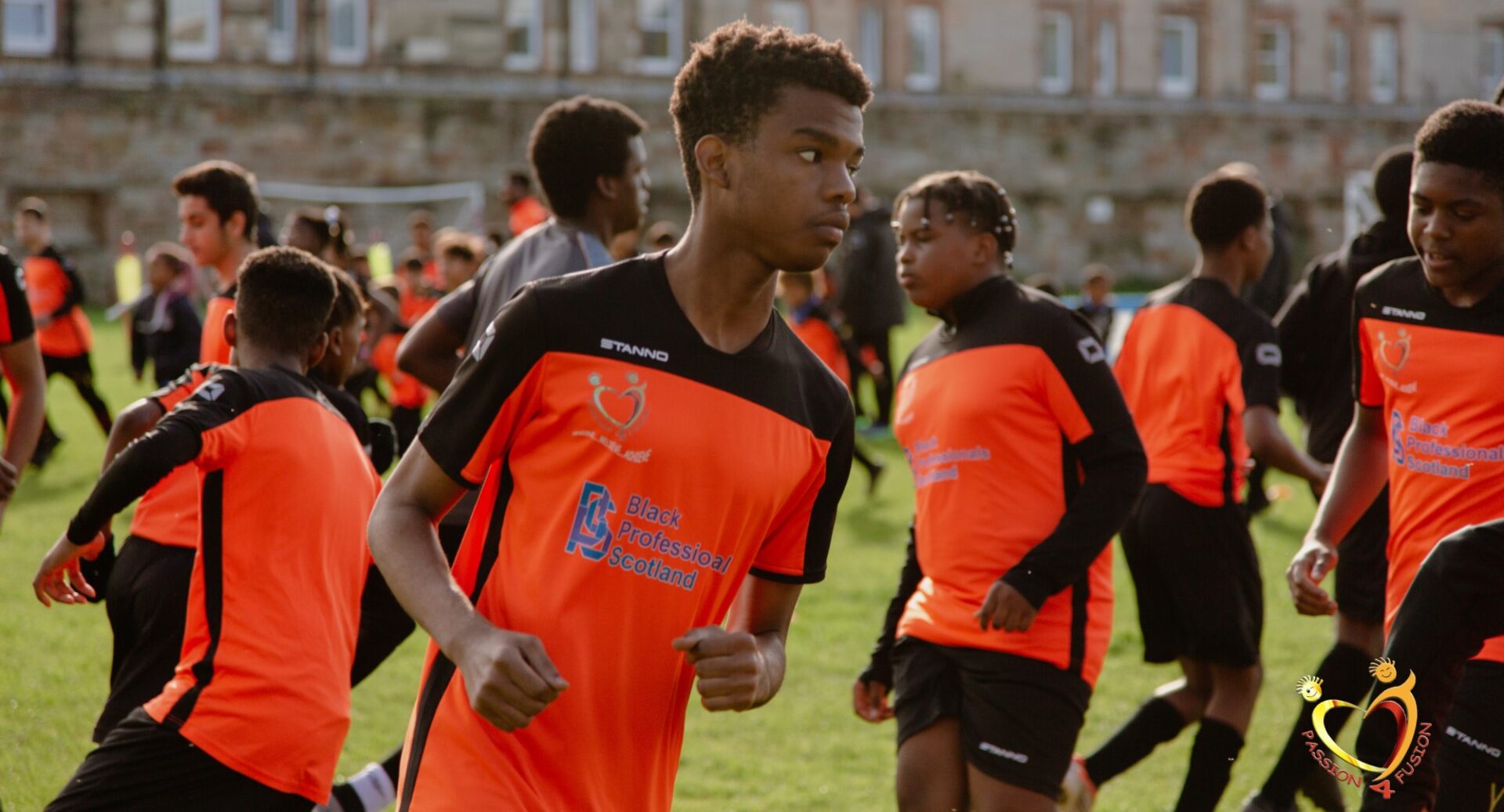 A group of footballers milling about in orange and black strips