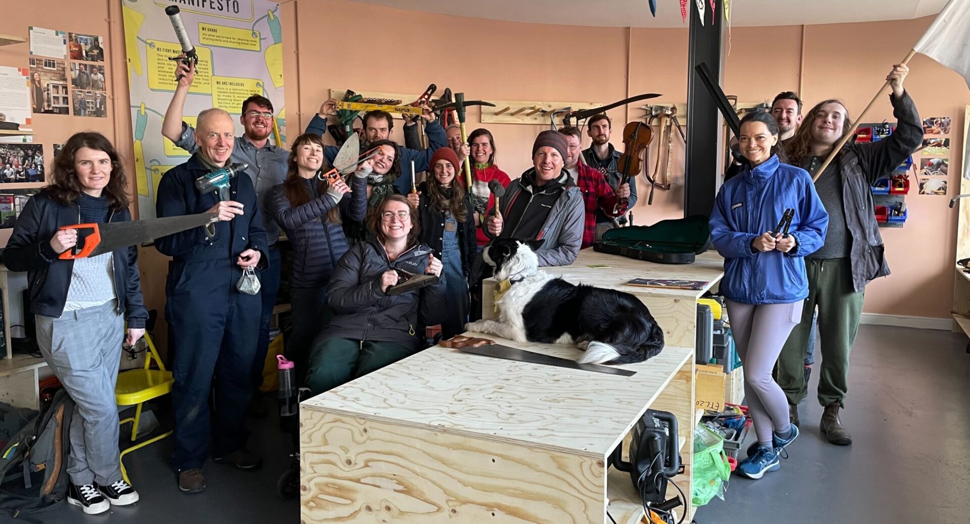 A group of people - and a border collie - armed with tools at the Tool Library