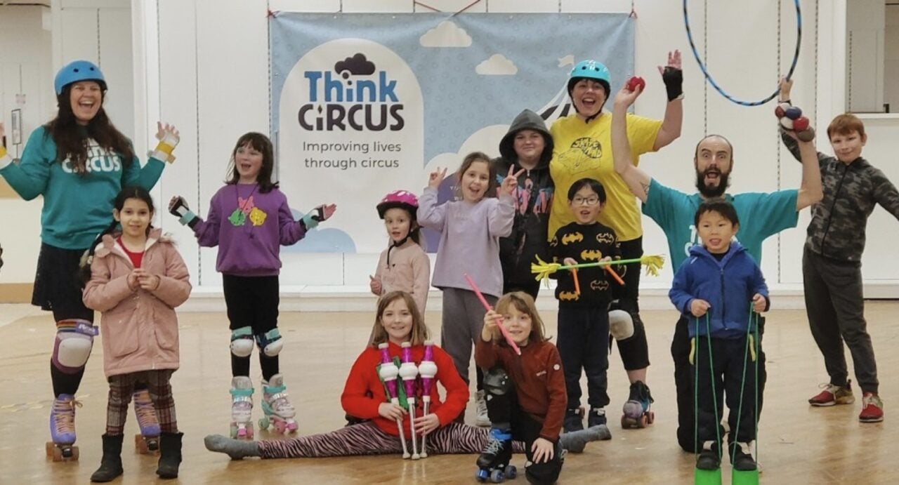 A group of children with hoops, rollerskates, and juggling implements