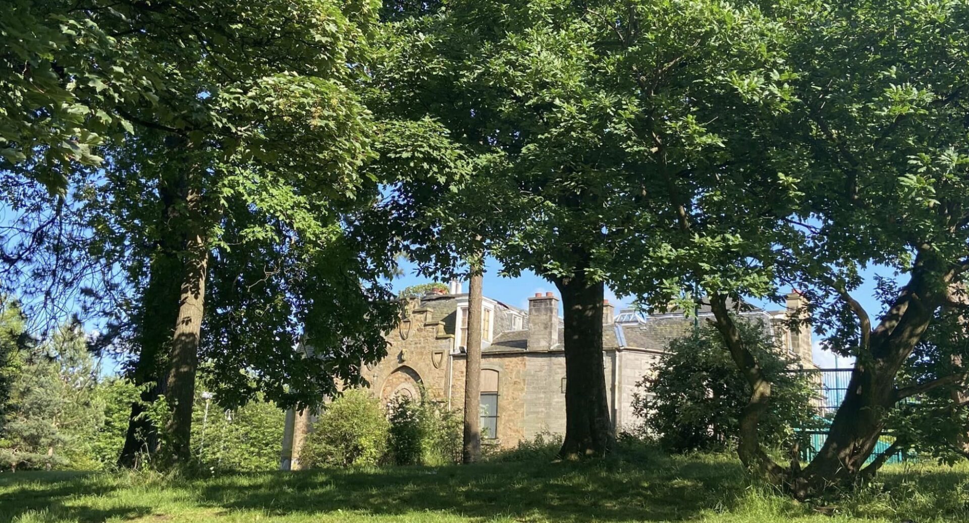 The stone exterior of Gracemount Mansion shot through the trees